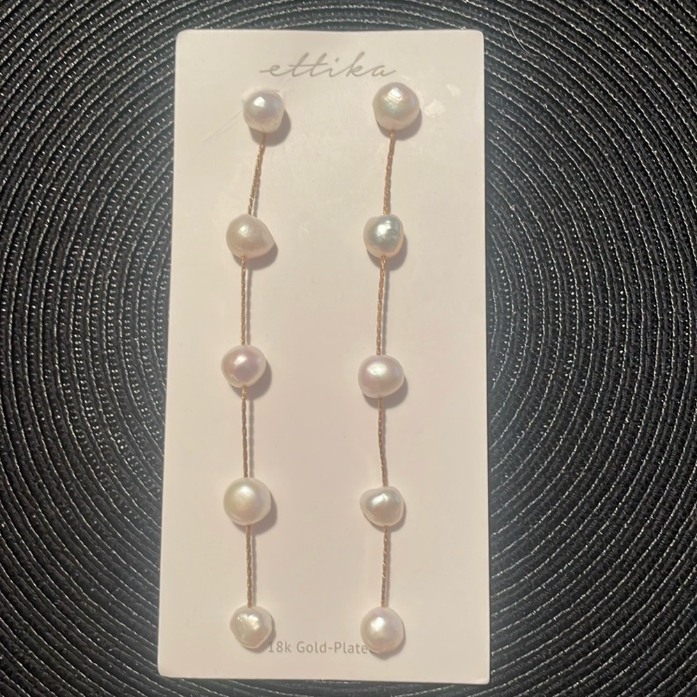 Ettika freshwater pearls long linear drop earrings plated in 18-karat gold.